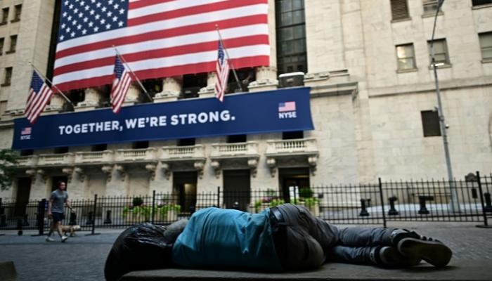 شخص يستلقي خارج سوق أسهم نيويورك