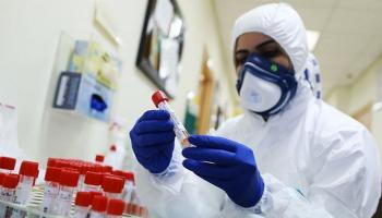 إحدى العاملات بالمركز الوطني لمكافحة الأمراض خلال إجراء تحاليل كورونا