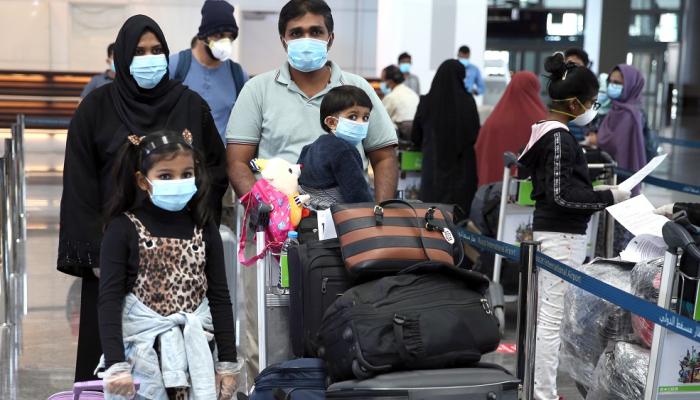 مسافرون يرتدون كمامات للوقاية من فيروس كورونا