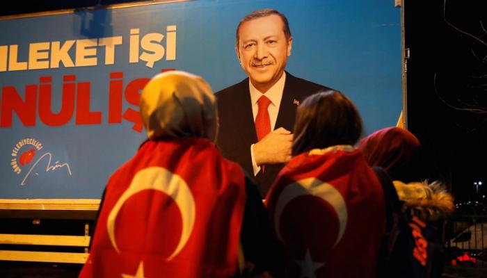 أنصار لأردوغان يقفون أمام لوحة للرئيس التركي - أرشيفية