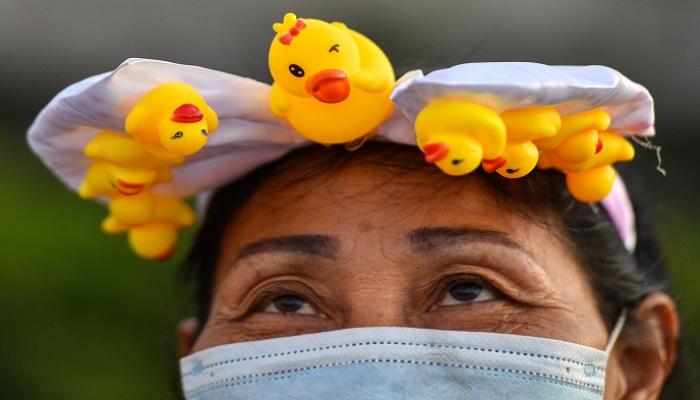 متظاهرة في تايلاند ترتدي رمز الاحتجاجات الجديد- أ.ف.ب