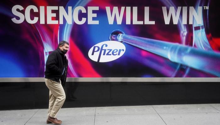 أمريكي يسير بجوار لافتة إعلانية لشركة فايزر في نيويورك