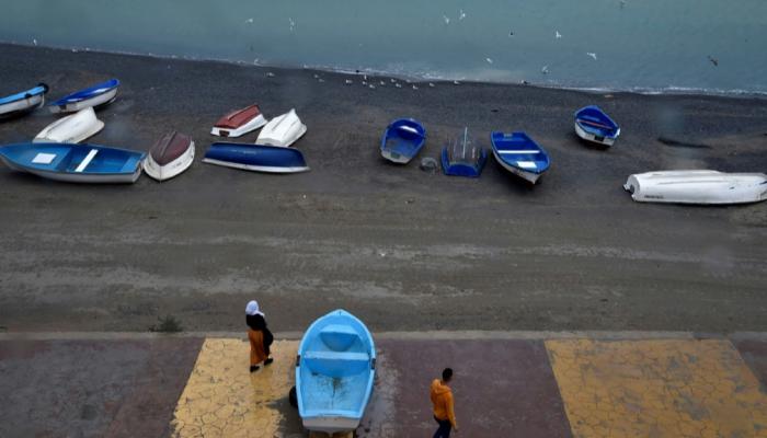 شباب يمشون على الواجهة البحرية في منطقة باب الواد الساحلية في الجزائر