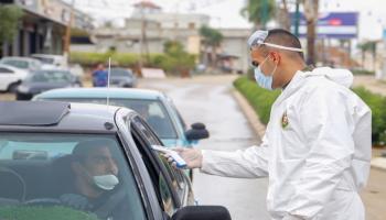 شخص يخضع لفحص درجة الحرارة بفلسطين