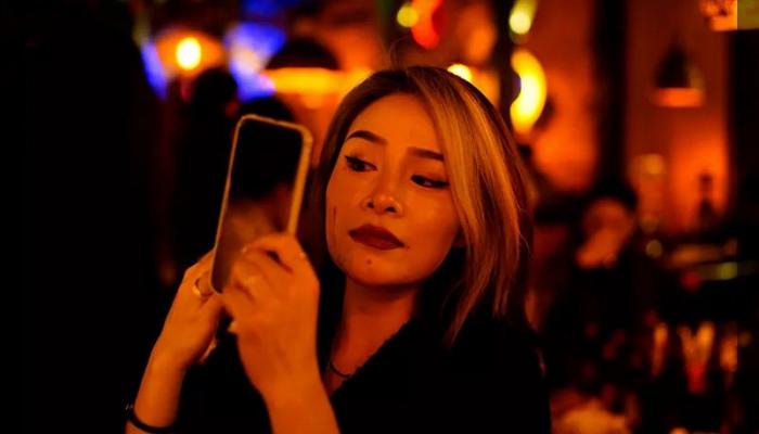 شابة صينية بووهان تعدل من مكياجها في المطعم بمناسبة عيد ميلادها - رويترز