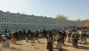 تجمع للحوثيين أمام حائط يحمل صور قتلاهم