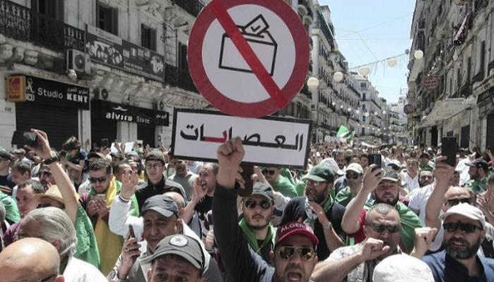 جزائريون يرفعون لافتة بها مطالب إنهاء تزوير الانتخابات - أرشيفية