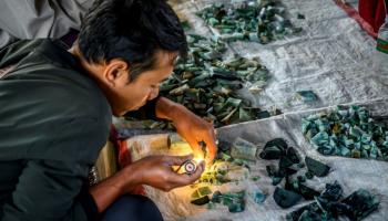 تاجر يتفحص أحجارا كريمة - أرشيفية