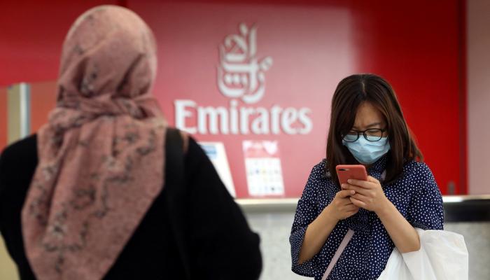 مسافرة في مطار دبي ترتدي الكمامة