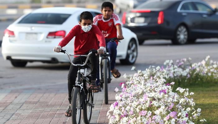 طفل سعودي يضع كمامة على فمه