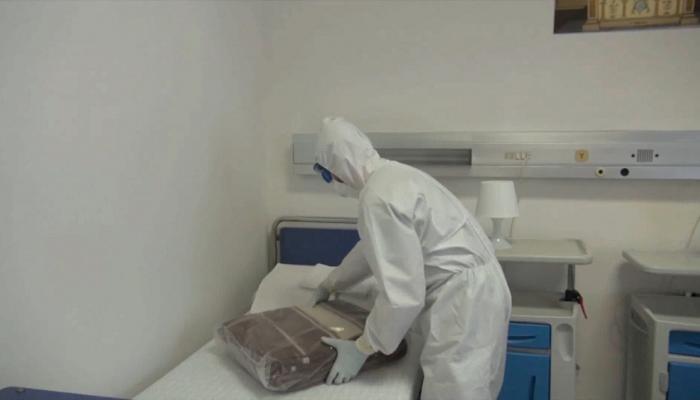 أحد المختصين يتولى تطهير غرفة بمستشفى عسكري في إيطاليا