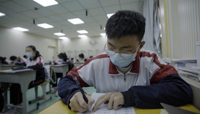 طالب صيني يرتدي كمامة ضمن الإجراءات الاحترازية لمواجهة كورونا