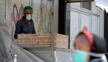 عامل في غزة يرتدي كمامة - أرشيفية