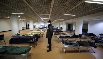 حارس أمن يرتدي كمامة داخل مأوى للمشردين في فرنسا