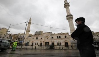 شرطي يرتدي كمامة في عمان