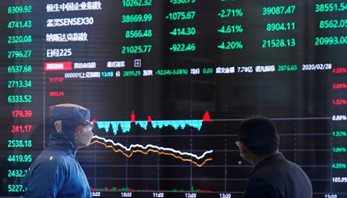 عامل يرتدي بدلة واقية داخل مبنى بورصة شنغهاي