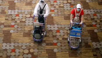 شخصان يرتديان أقنعة واقية وقفازات للوقاية من فيروس كورونا