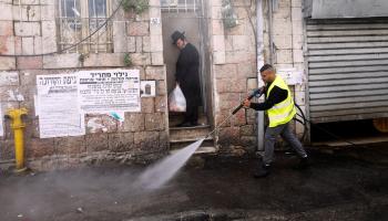 عامل يرش الشارع بالمطهرات