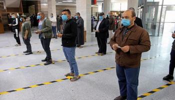 ليبيون يرتدون كمامات أمام أحد البنوك في مصراتة