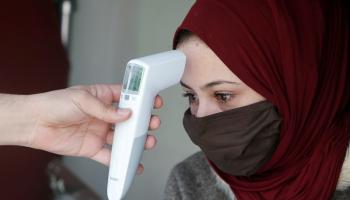 أردنية تخضع لفحص درجة الحرارة للتأكد من عدم إصابتها بفيروس كورونا