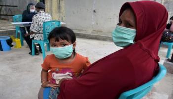 سيدة ترتدي كمامة هي وابنتها خشية عدوى كورونا