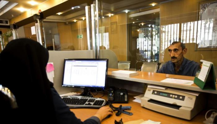 موظفة وعميل داخل بنك محلي في إيران - أرشيفية