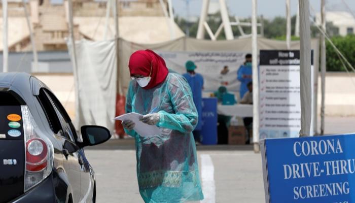 عاملة صحية في باكستان تأخذ تاريخا طبيا من رجل في سيارة - رويترز