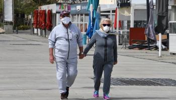 شخصان يتجولان مرتديان كمامة للوقاية من كورونا