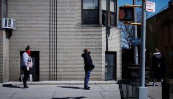 متسوقون ينتظرون على رصيف للدخول إلى متجر في نيويورك