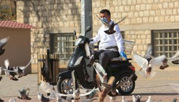 رجل عراقي يرتدي قناع وجه وقفازات للوقاية من فيروس كورونا