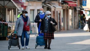 أشخاص يرتدون كمامات للوقاية من عدوى كورونا في إيطاليا