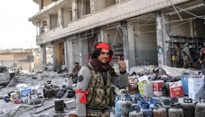 عنصر من مليشيات موالية لتركيا خلال سرقة متاجر في عفرين