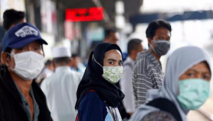 إندونيسيون يرتدون الكمامات خشية كورونا