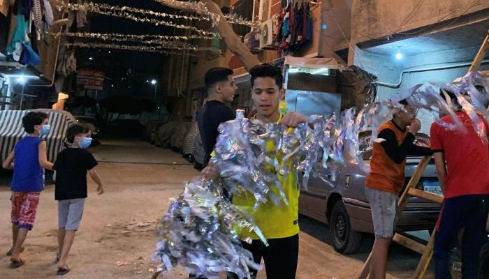 شباب يعلقون زينة رمضان في مصر