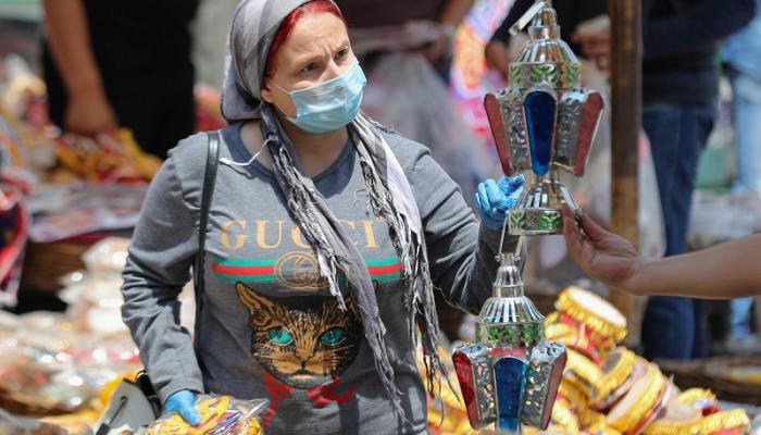مصرية ترتدي الكمامة في أحد شوارع القاهرة وتستعد لشراء فانوس رمضان