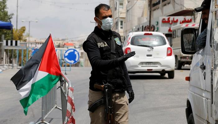 شرطي فلسطيني عند نقطة تفتيش - رويترز