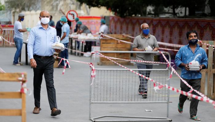 رجال يرتدون كمامات للوقاية من كورونا في المنامة