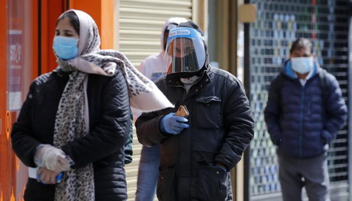 بريطانيون يرتدون الكمامات خارج مكتب بريد في لندن