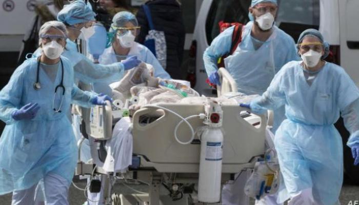 فريق طبي ينقل مصابا بكورونا إلى المستشفى