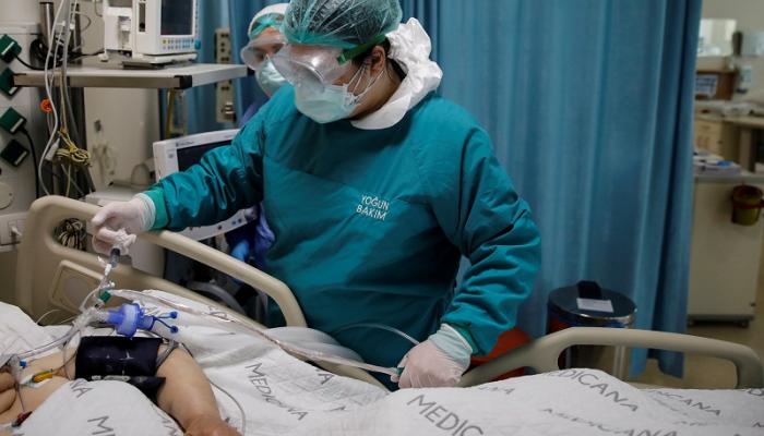 طبيبة تفحص مصابا بفيروس كورونا في وحدة للعناية المركزة