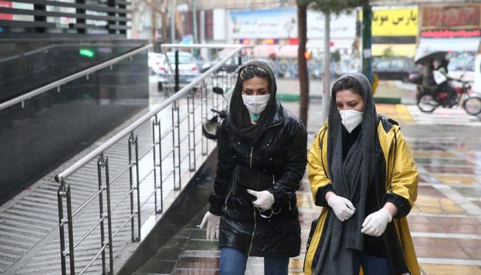 سيدتان ترتديان الكمامات في أحد شوارع طهران