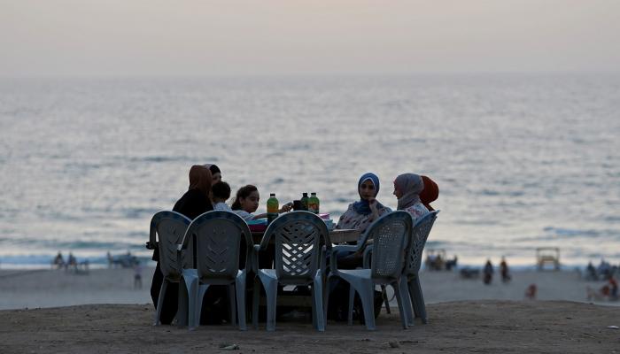 أسرة تستعد لتناول وجبة الإفطار على شاطئ غزة