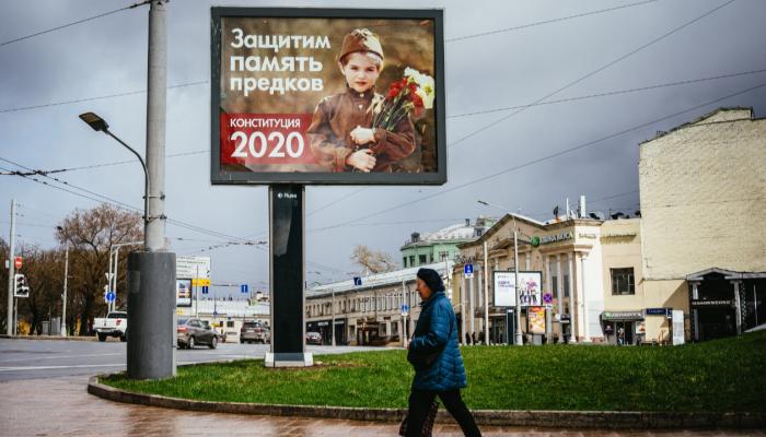 امرأة تمر من أمام لوحة إعلان استفتاء دستوري في موسكو