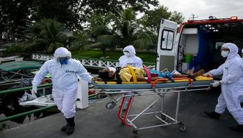 مسعفون خلال نقل مصاب بكورونا للمستشفى- أرشيفية