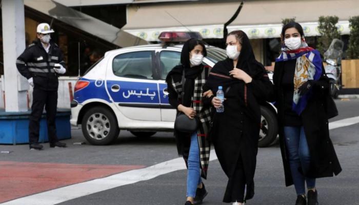 3 فتيات يرتدين الكمامات في أحد شوارع طهران