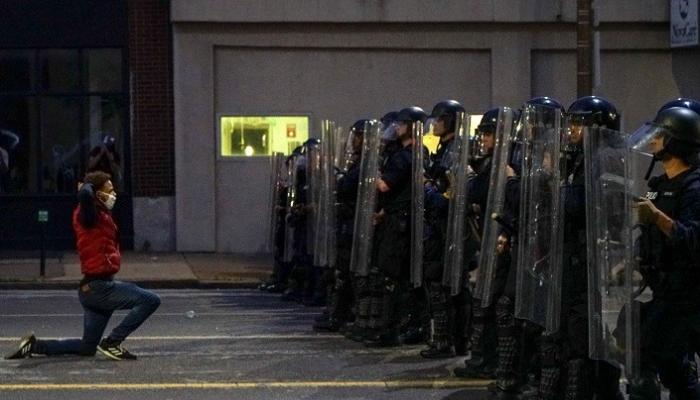 متظاهر أمريكي يواجه قوات الشرطة خلال احتجاجات على مقتل فلويد