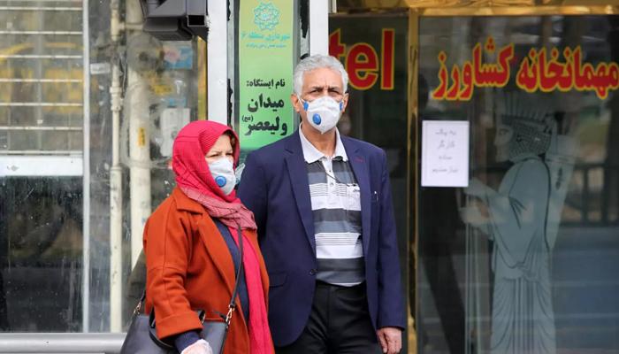 شخصان يرتديان الكمامات في أحد شوارع طهران