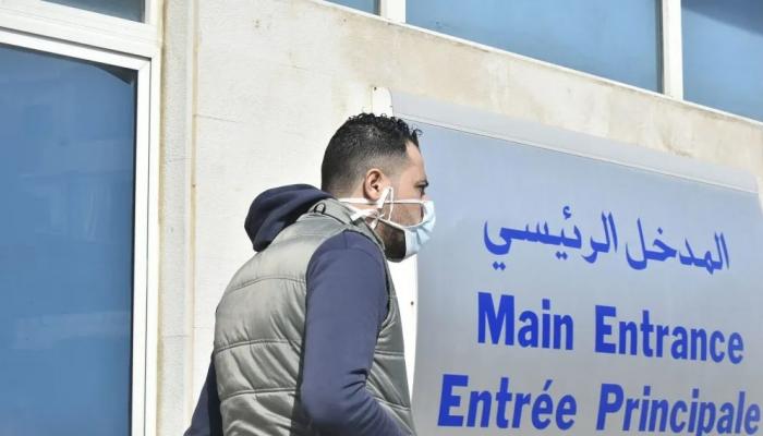 شخصان يرتديان الكمامات أمام مستشفى رفيق الحريري في بيروت