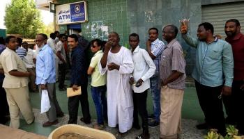سودانيون قرب ماكينة صراف آلي - رويترز