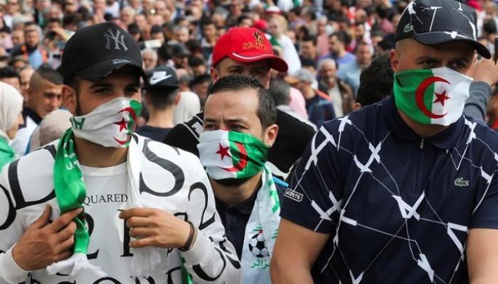 جزائريون يستعملون علم بلادهم كمامة للوقاية من كورونا - أرشيفية